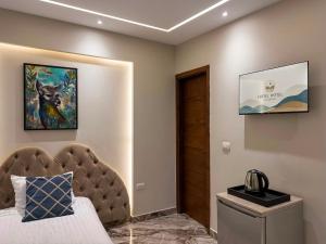 a bedroom with a bed and a painting on the wall at Dera October city in 6th Of October