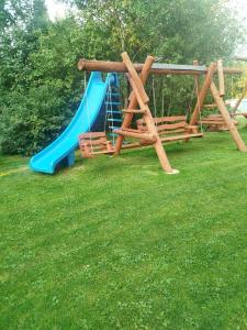 a playground with a blue slide in a yard at Nad Grapą in Gliczarów