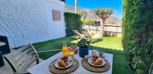 a table with plates of food and orange juice at Maresía Village in Los Realejos