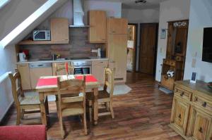 a kitchen with a wooden table and a dining room at Familie Stoier in Reichenau