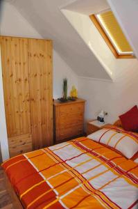 a bedroom with a bed with an orange and white blanket at Familie Stoier in Reichenau