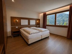 a bedroom with a bed and a large window at Ciasa de Zeno in La Valle