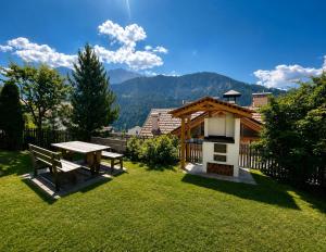 a picnic table and a bench in a yard at Ciasa de Zeno in La Valle