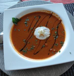 a bowl of tomato soup with a dollop of sour cream at Pi-Buddy Lodge and Bushcamp in Outjo +18 photos
