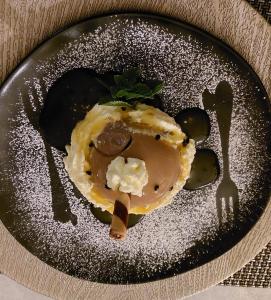 a black plate with a dessert on a table at Pi-Buddy Lodge and Bushcamp in Outjo
