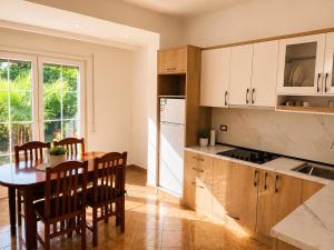 a kitchen with a wooden table and a dining room at Villa Ajla- Entire Villa in Durrës