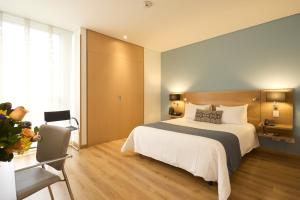 a bedroom with a large white bed and wooden floors at Hotel bh Parque 93 in Bogotá