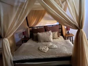a bedroom with a bed with drapes at chalet de paradis in Bizerte