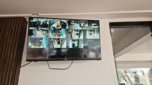 a flat screen tv hanging on a wall next to a window at Arul Rayara Residency in Mādhavaram