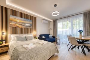 a bedroom with a bed and a table and chairs at Wydmove Łeba Q4 Apartments in Łeba