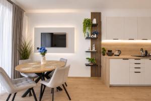 a kitchen and dining room with a table and chairs at Wydmove Łeba Q4 Apartments in Łeba