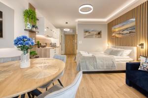 a bedroom and living room with a bed and a table at Wydmove Łeba Q4 Apartments in Łeba +166 photos