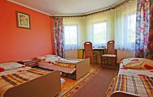 a room with three beds and a table and chairs at Juhas in Zwardoń