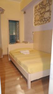 a bedroom with a large bed with yellow sheets at Marina Poetto in Cagliari