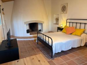 a bedroom with a bed and a fireplace at Vale da Lama in Almodôvar +30 photos