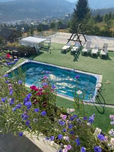 a swimming pool with flowers in a yard at Chalet Trushnyi in Palyanytsya