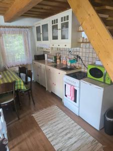 a kitchen with a white stove top oven next to a table at Chata Sandra in Revúca