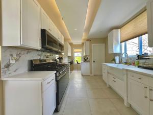 a kitchen with white cabinets and a stove top oven at Clinton Rooms - By Outlets and Beach in Clinton +6 photos