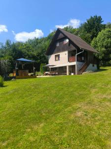 a house with a large yard with a grass field at Chata Sandra in Revúca
