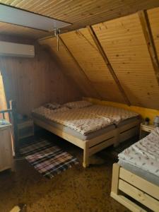 a room with a bed in a attic with a mattress at Chata Sandra in Revúca