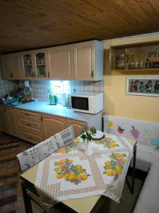 a kitchen with a table and chairs and a microwave at Chata Sandra in Revúca +22 photos