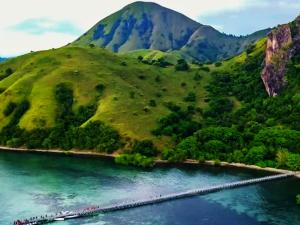 a group of boats in the water next to a mountain at Azmy Adventure in Pawenang