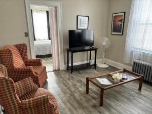 a living room with a tv and chairs and a coffee table at The Elizabeth Suite B2 in Hartford