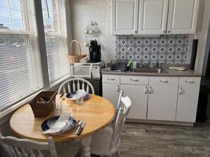a kitchen with a wooden table and white cabinets at The Elizabeth Suite B2 in Hartford