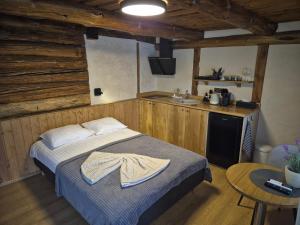 a bedroom with a bed and a kitchen with a sink at Kütioru saunamajad in Koloreino +22 photos