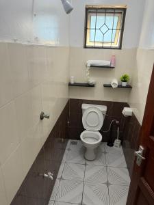 a bathroom with a toilet and a window at Harmony serenity studio apartment in Mombasa