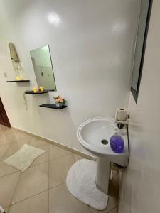 a white bathroom with a sink and a mirror at Harmony serenity studio apartment in Mombasa