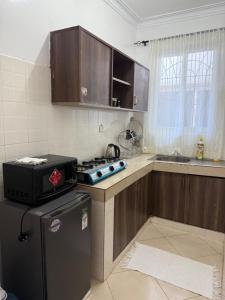 a kitchen with a refrigerator and a stove in it at Harmony serenity studio apartment in Mombasa