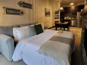 a bedroom with a large bed and a couch at Tremblant Prestige - Étoile 1520-2 in Mont-Tremblant