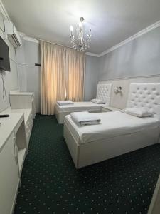a bedroom with two beds and a chandelier at MIR Hotel in Türkistan