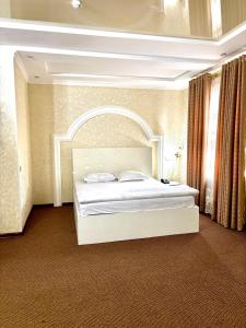 a bedroom with a large white bed in a room at MIR Hotel in Türkistan +8 photos