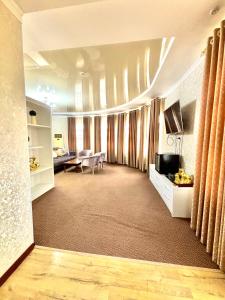 a large living room with a tv and a couch at MIR Hotel in Türkistan