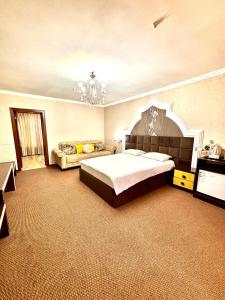 a large bedroom with a large bed and a chandelier at MIR Hotel in Türkistan