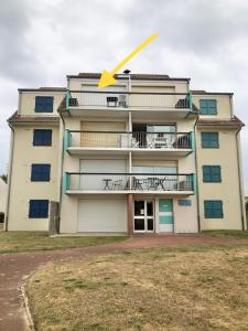 a building with a yellow arrow on top of it at Studio centre ville - 5min de la plage in Neufchâtel-Hardelot