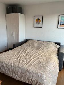 a bedroom with a bed with a blanket on it at Studio centre ville - 5min de la plage in Neufchâtel-Hardelot