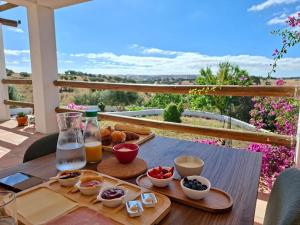 a table with a tray of breakfast food on a balcony at Vale da Lama in Almodôvar
