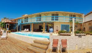 a house with a swimming pool in front of it at Pousada Azul Marinho in Canoa Quebrada