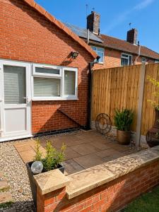 a brick house with a patio and a fence at Studio 38 in Leicester