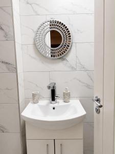 a white bathroom with a sink and a mirror at Studio 38 in Leicester
