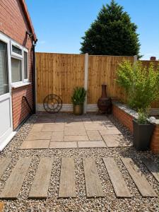 a patio in front of a wooden fence with plants at Studio 38 in Leicester