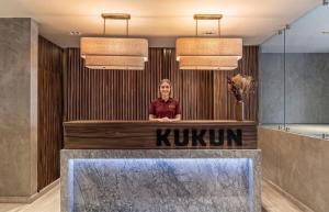 a woman standing behind a counter in a hotel lobby at Kukun Tonala 30 Roma in Mexico City