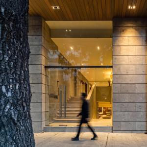 a person walking past a building with a window at Kukun Tonala 30 Roma in Mexico City