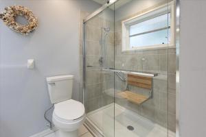 a bathroom with a toilet and a glass shower at Palm Tree Parasdise in Englewood