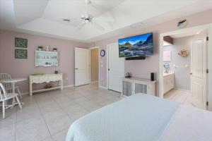 a bedroom with a bed and a tv on a wall at Palm Tree Parasdise in Englewood