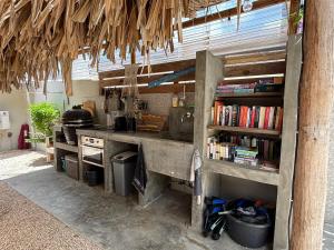a kitchen with a sink and a stove and books at BnBBonaire near the ocean in Kralendijk