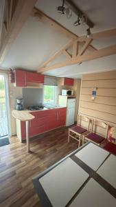 a kitchen with red cabinets and a table and chairs at Casa Apolinario in Ílhavo +9 photos
